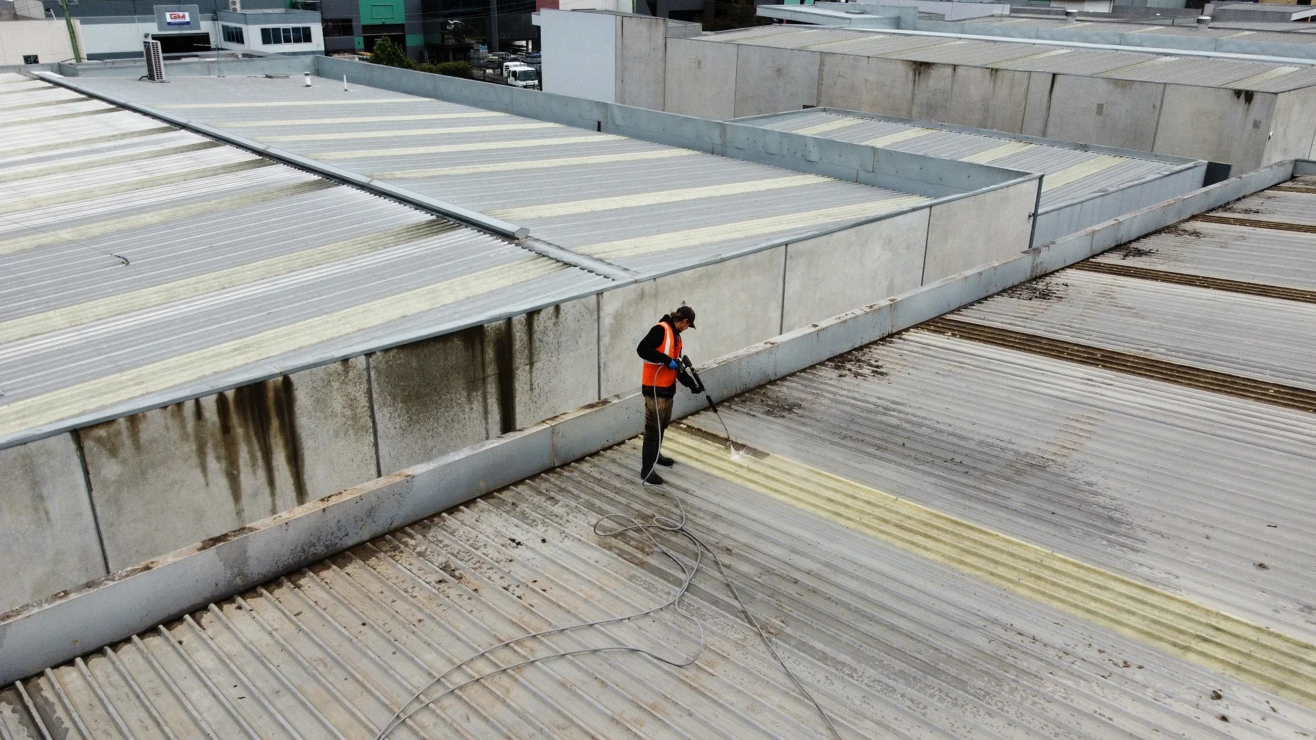 Technician cleaning a commercial factory roof